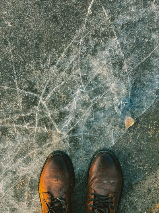 the person with shoes is standing outside on a sidewalk