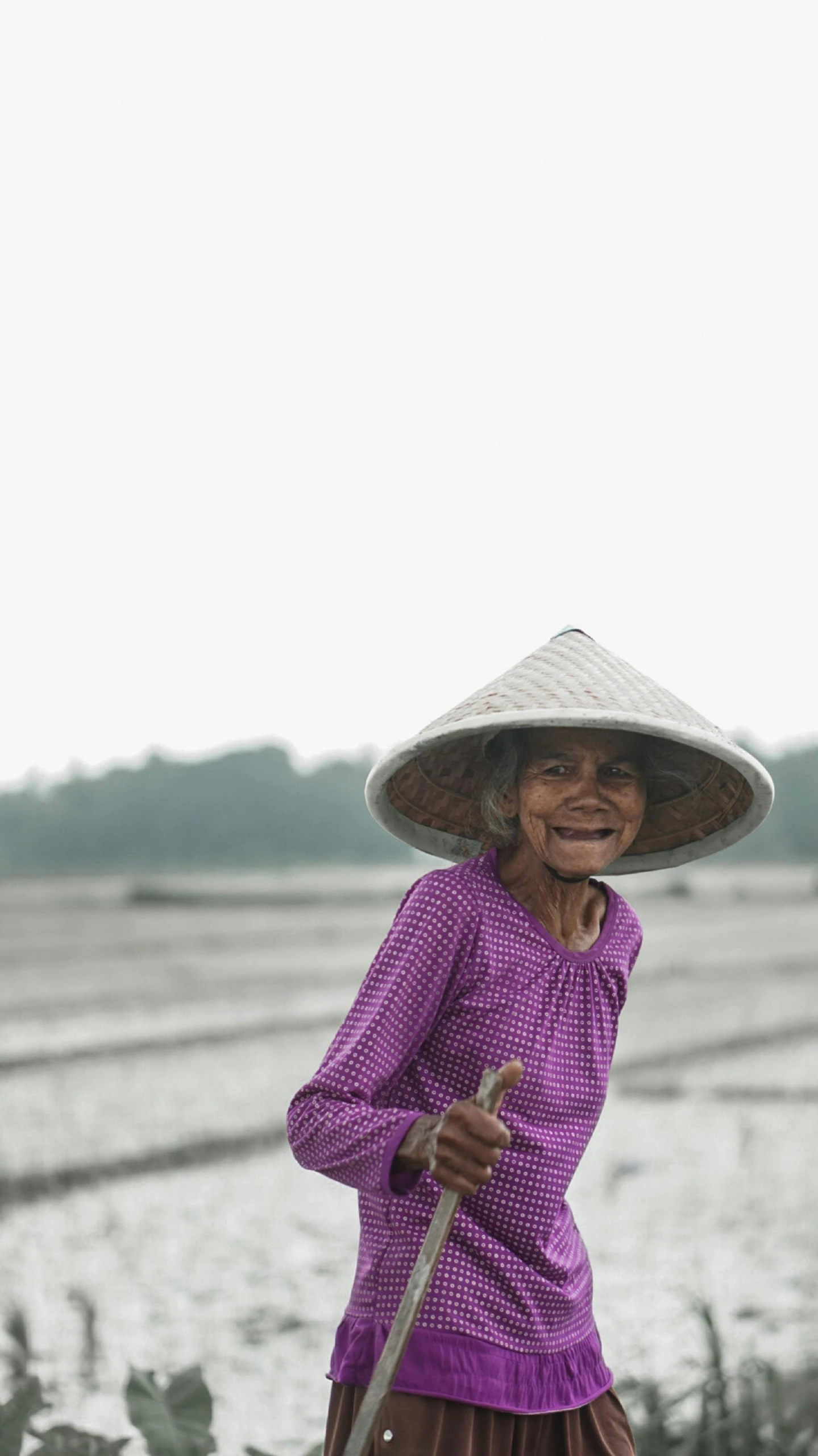 a woman wearing a big hat carrying an umbrella