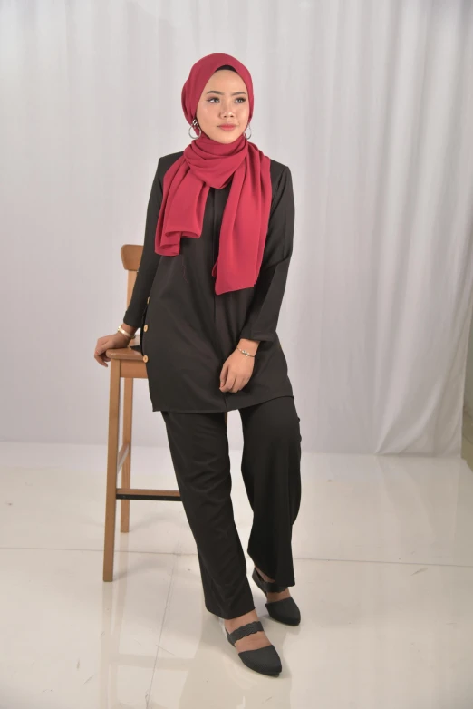 a woman with a hijab is sitting on a chair