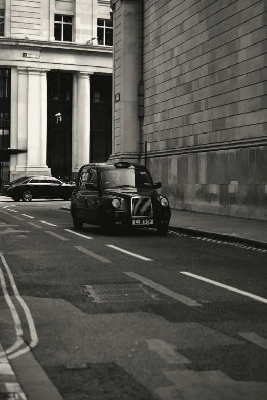 a taxi driving down the street in front of tall buildings