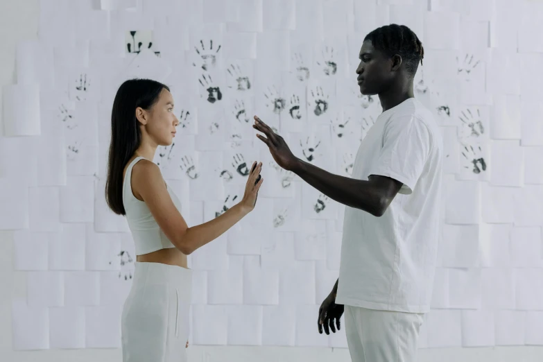 a man and woman holding hands in front of many hand prints