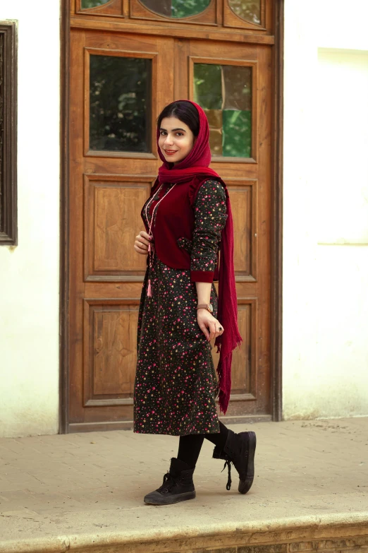 a young woman is posing outside a door