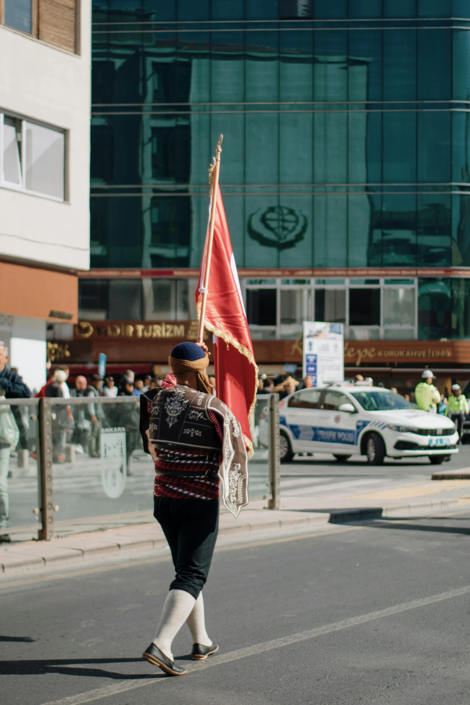 a person carrying a flag down the road