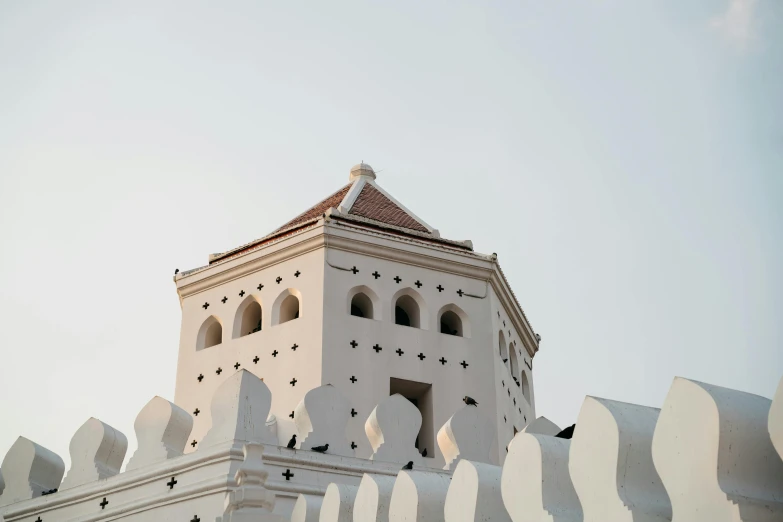 a white building with a tower with a red roof