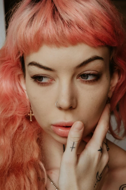 woman with tattoos wearing hoop earrings and finger rings