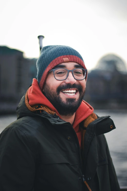 a man with glasses and a beard, wearing a beanie and a jacket