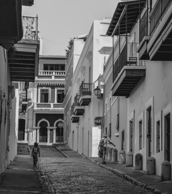 a narrow street with multiple balconies and windows on both sides