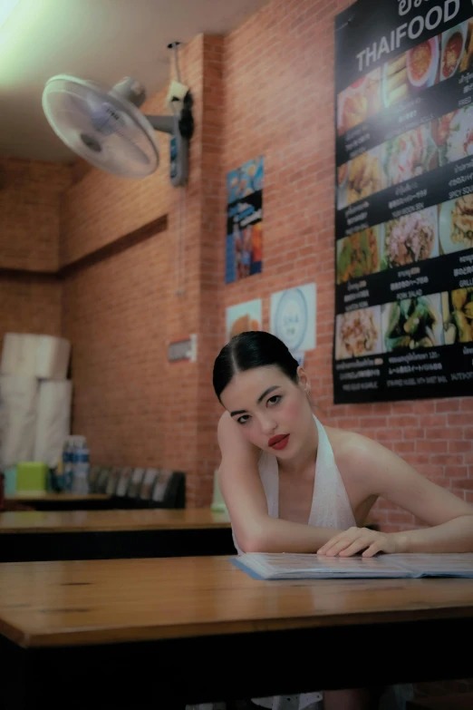 an asian woman resting her head on the table