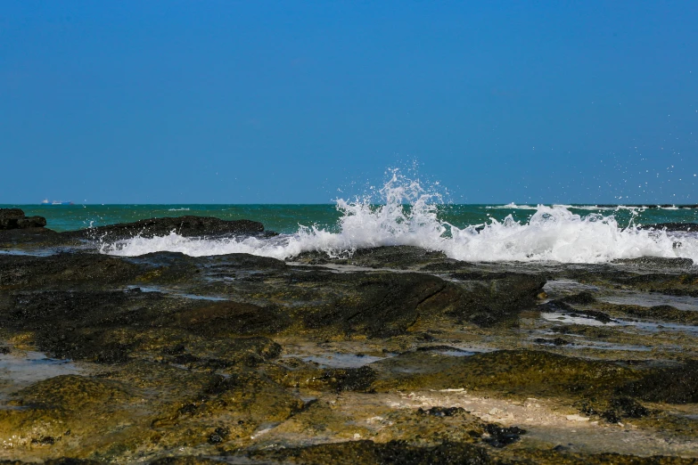 an ocean wave crashes onto the shore