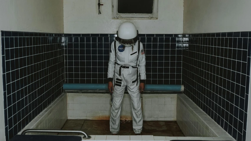 a spaceman standing in a restroom in his space suit