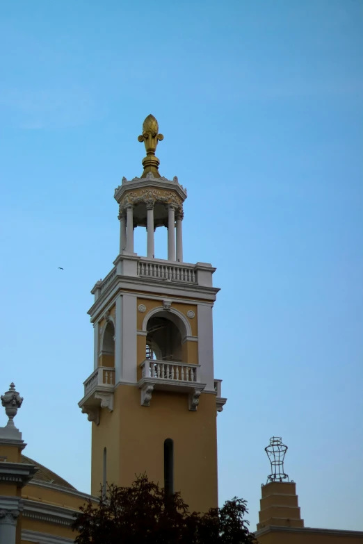 an ornate building with a bell tower and two golden statues on top