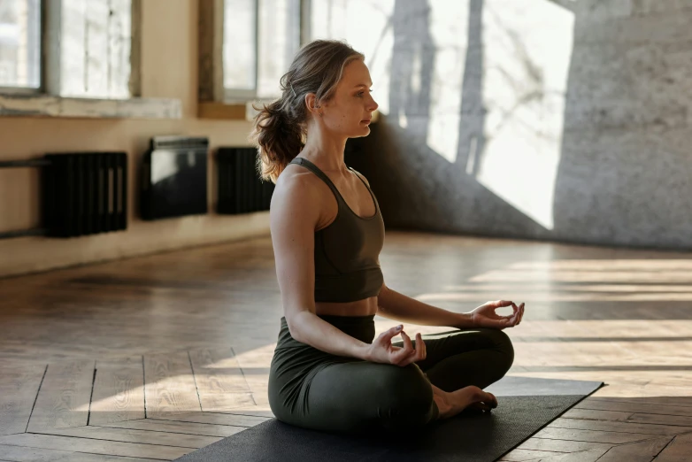 a woman practicing yoga in a room with brick walls