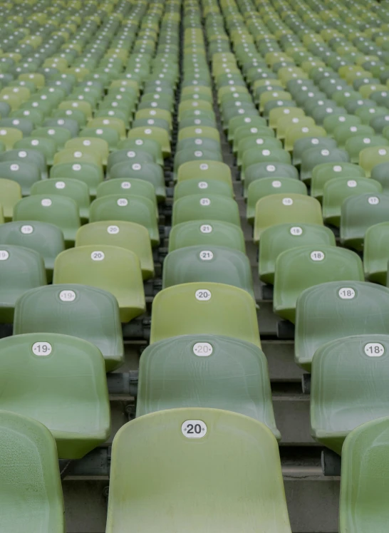 a large empty stadium with rows of green seats