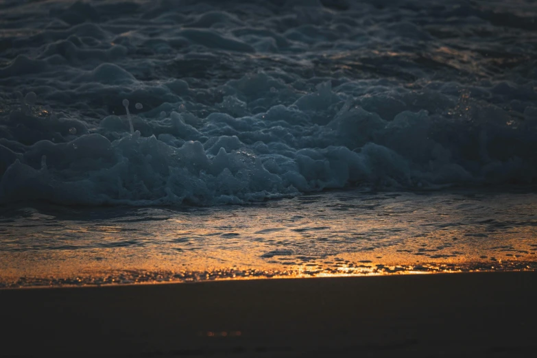 a close up of water and sand at a beach