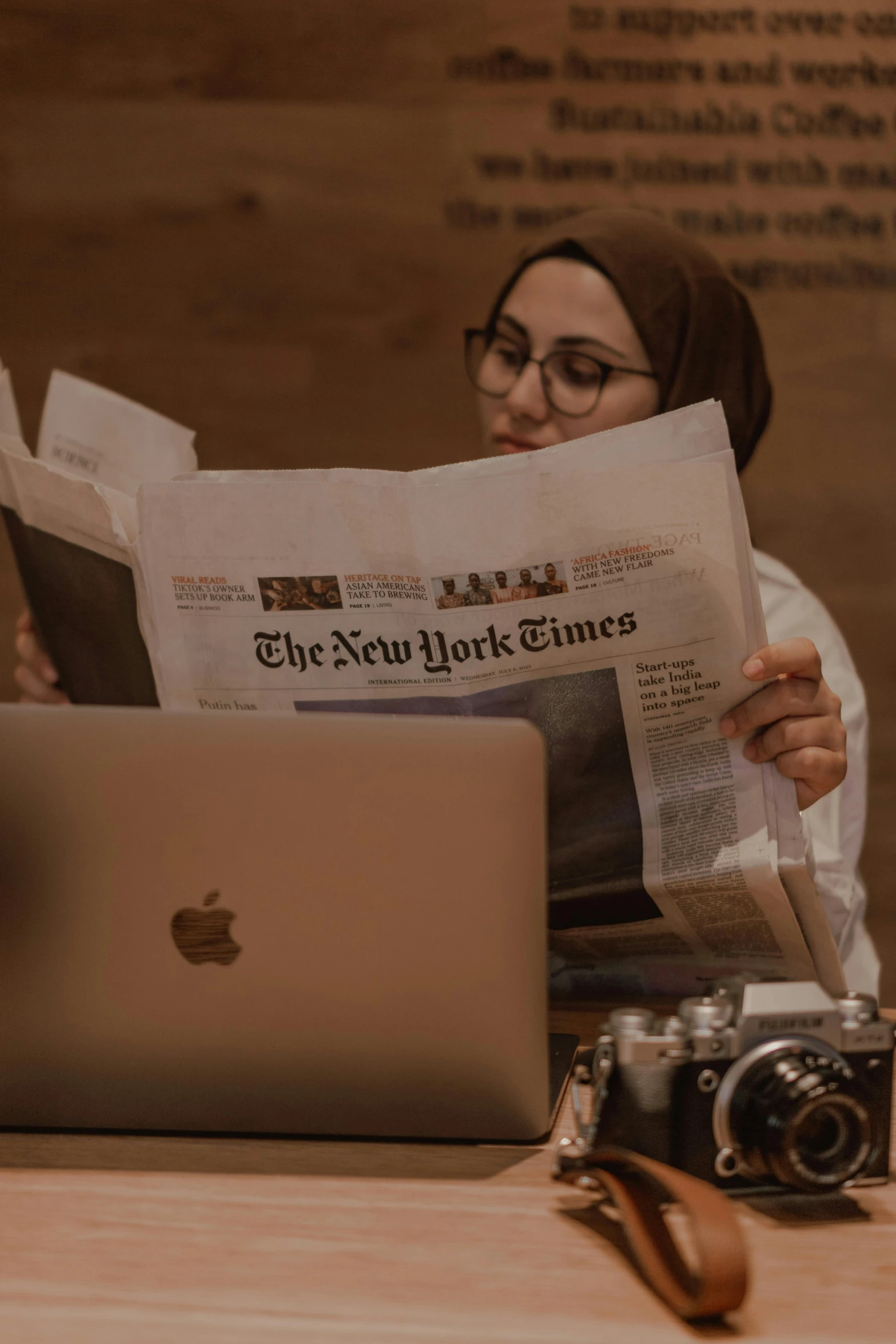 an asian woman is reading the new york times on her laptop