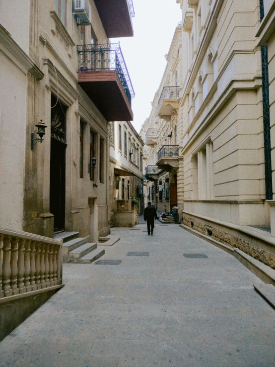 two people walk on an alley way in a city