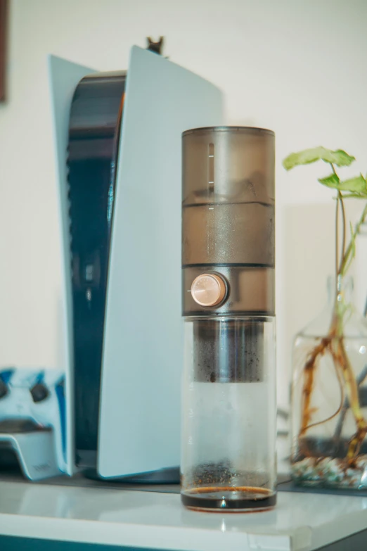 a computer with a metal stand holding a bottle