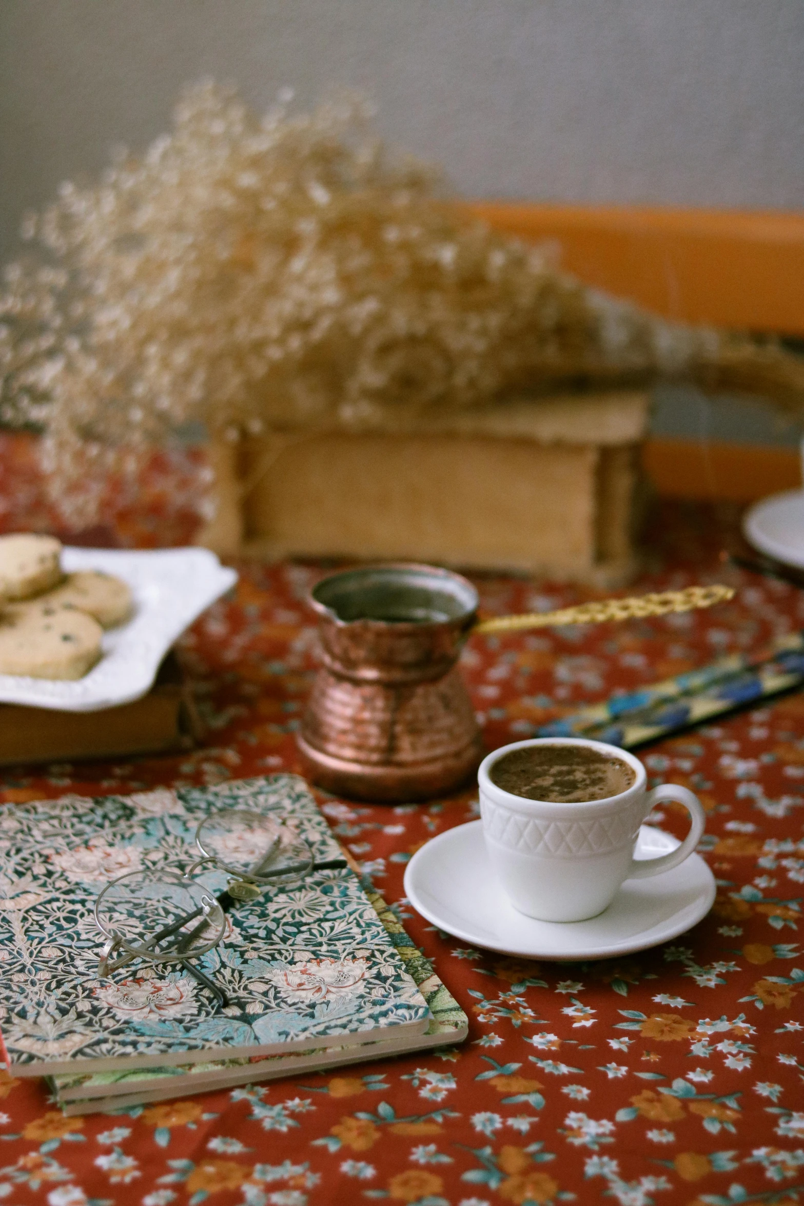 cup of coffee and cookies next to book