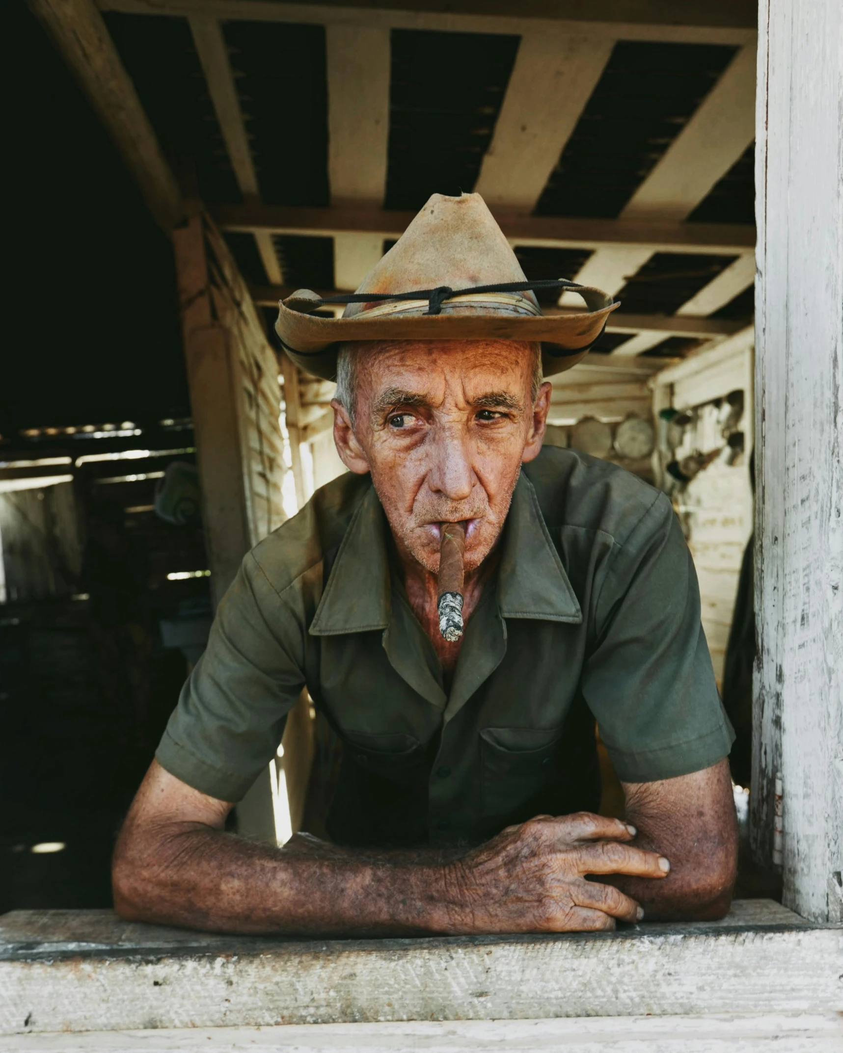 an old man in a cowboy hat poses for a pograph