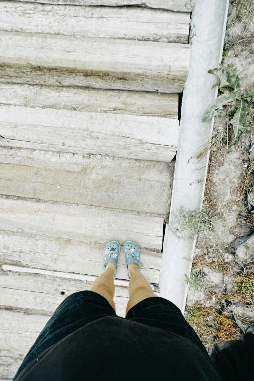 person walking along stairs with their shoes in the air