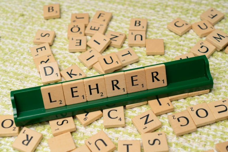 scrabbled wooden letters, numbers and punctur numbers lie scattered across a table