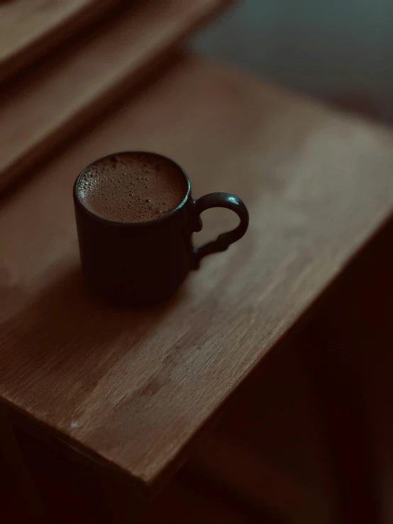 a black cup is sitting on a table
