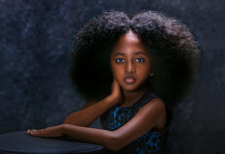 the young african girl is posing with her hair blowing