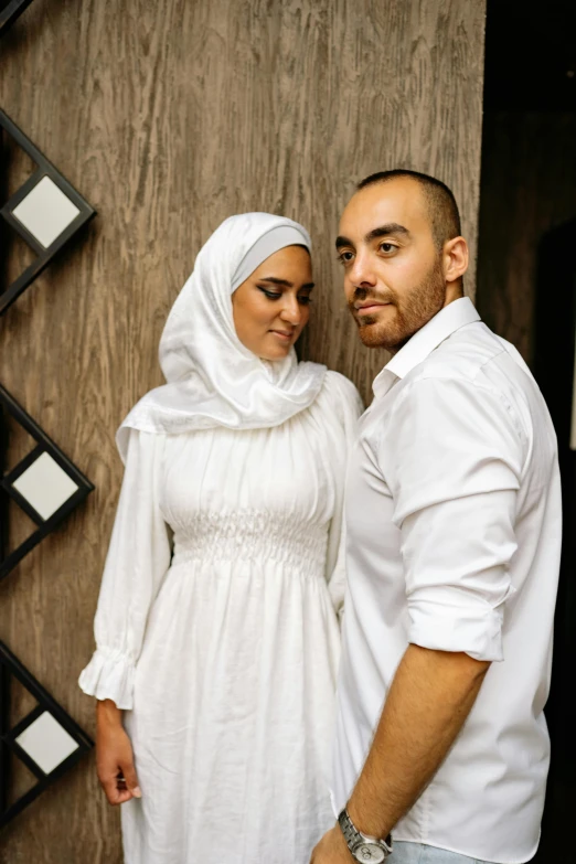 a young couple standing together near a wall