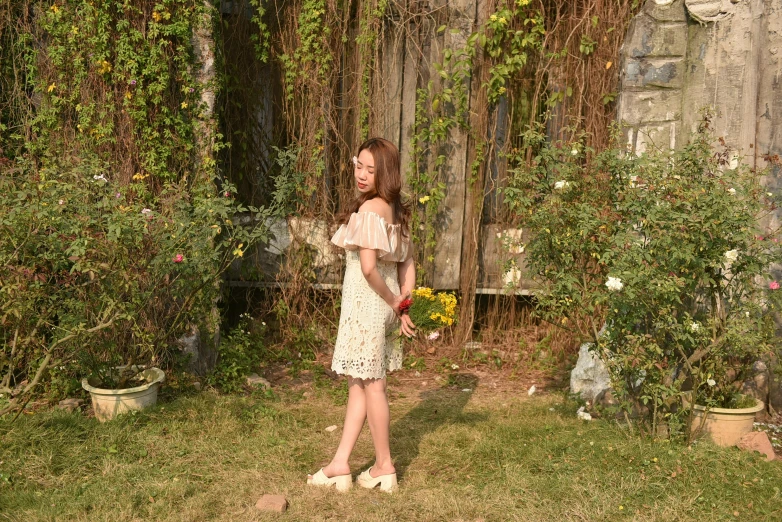 a woman is standing outside by a fence