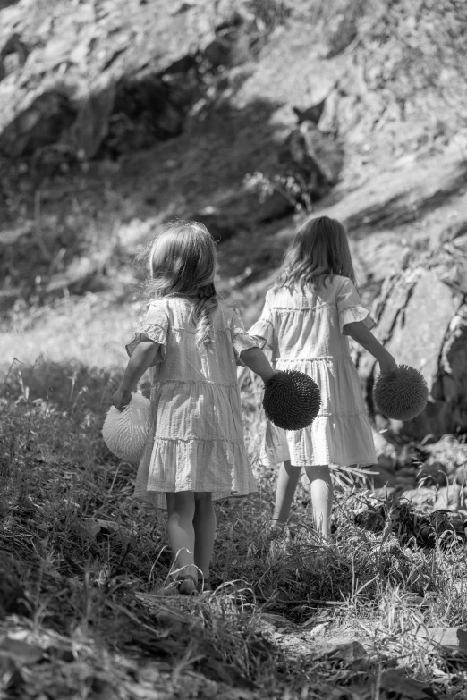 a couple of little girls walking through the grass