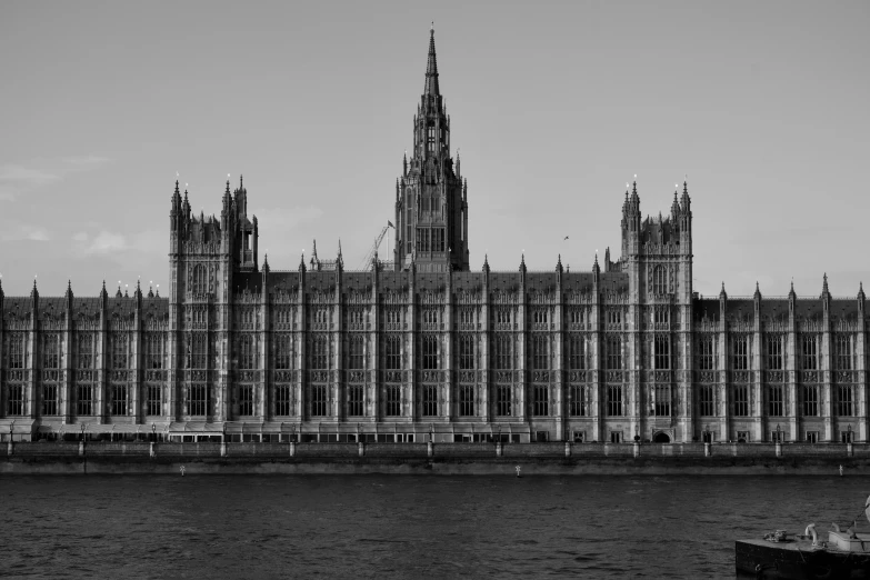 a boat floats by a castle in black and white