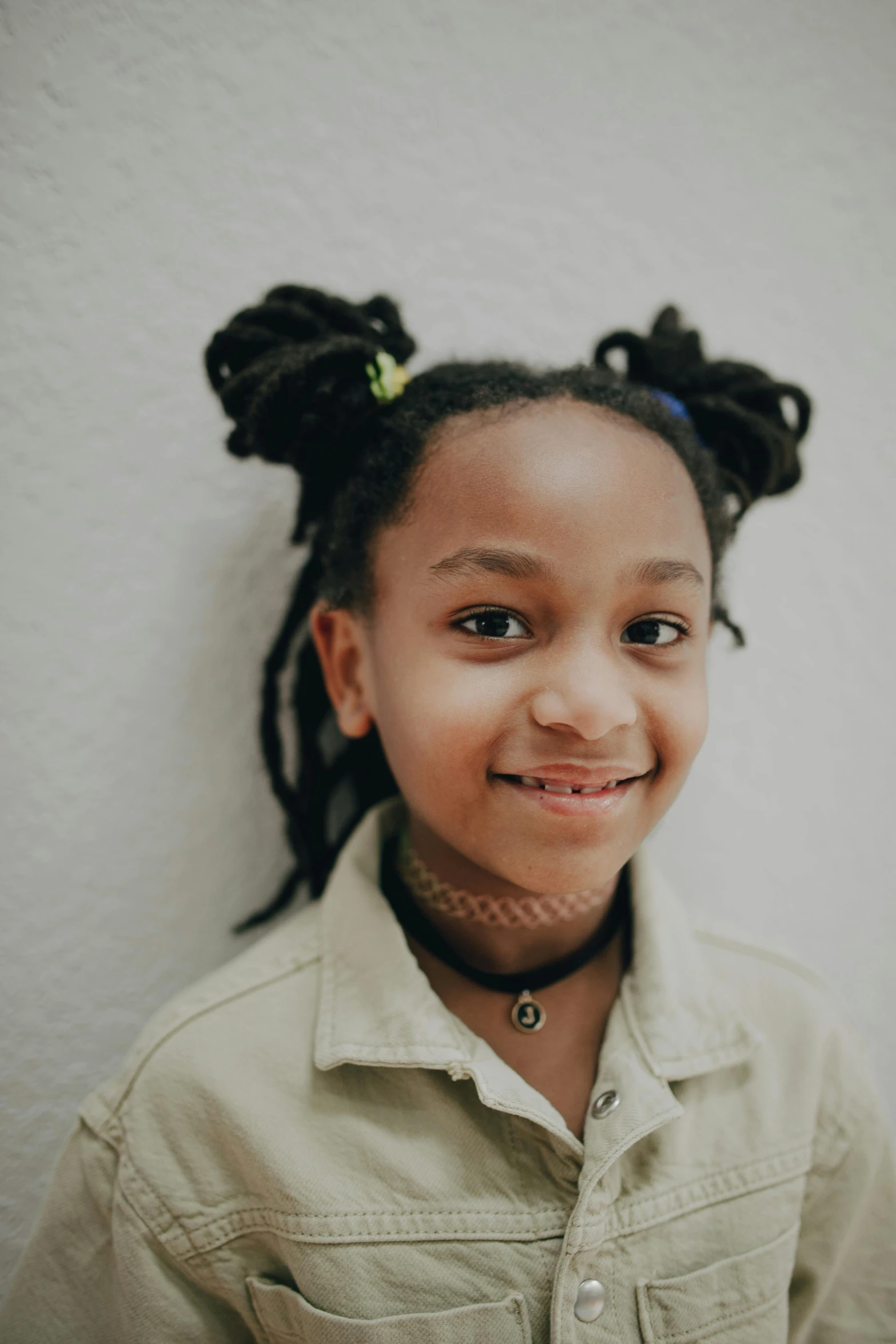  smiling in front of wall with ponytails