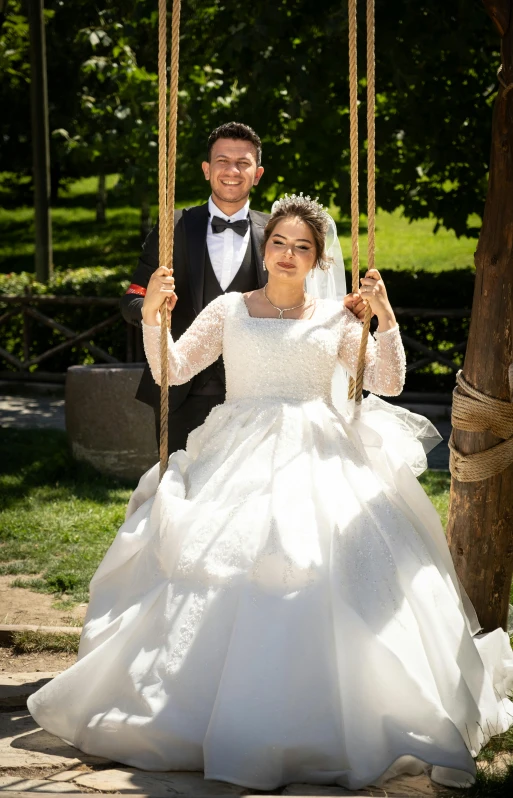 a bride and groom on a swing outside