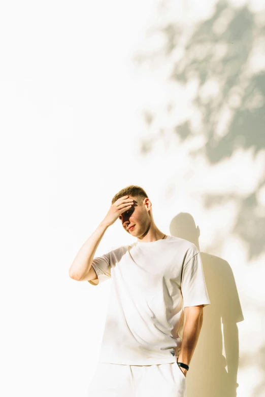 a young man standing on a concrete floor in front of a wall