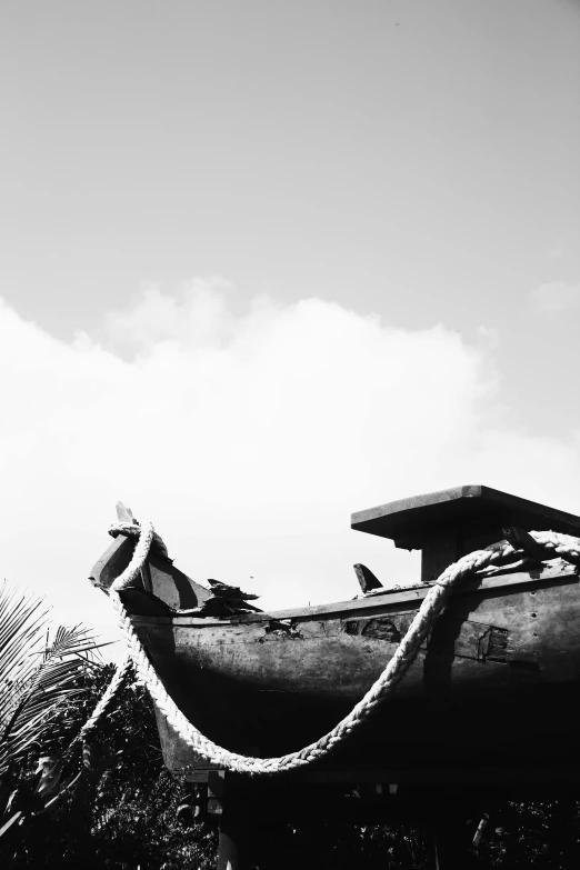 a old boat with rope on it sits in the grass