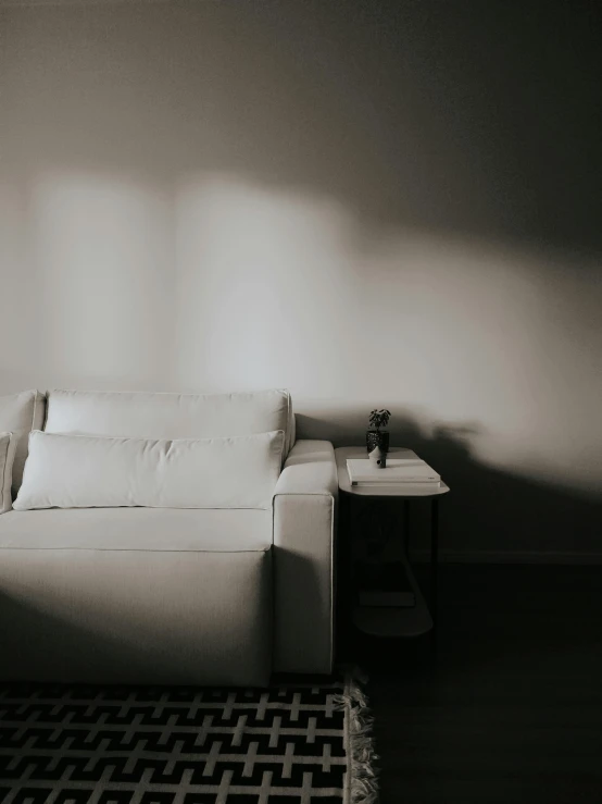 white couch sitting next to a table and wall