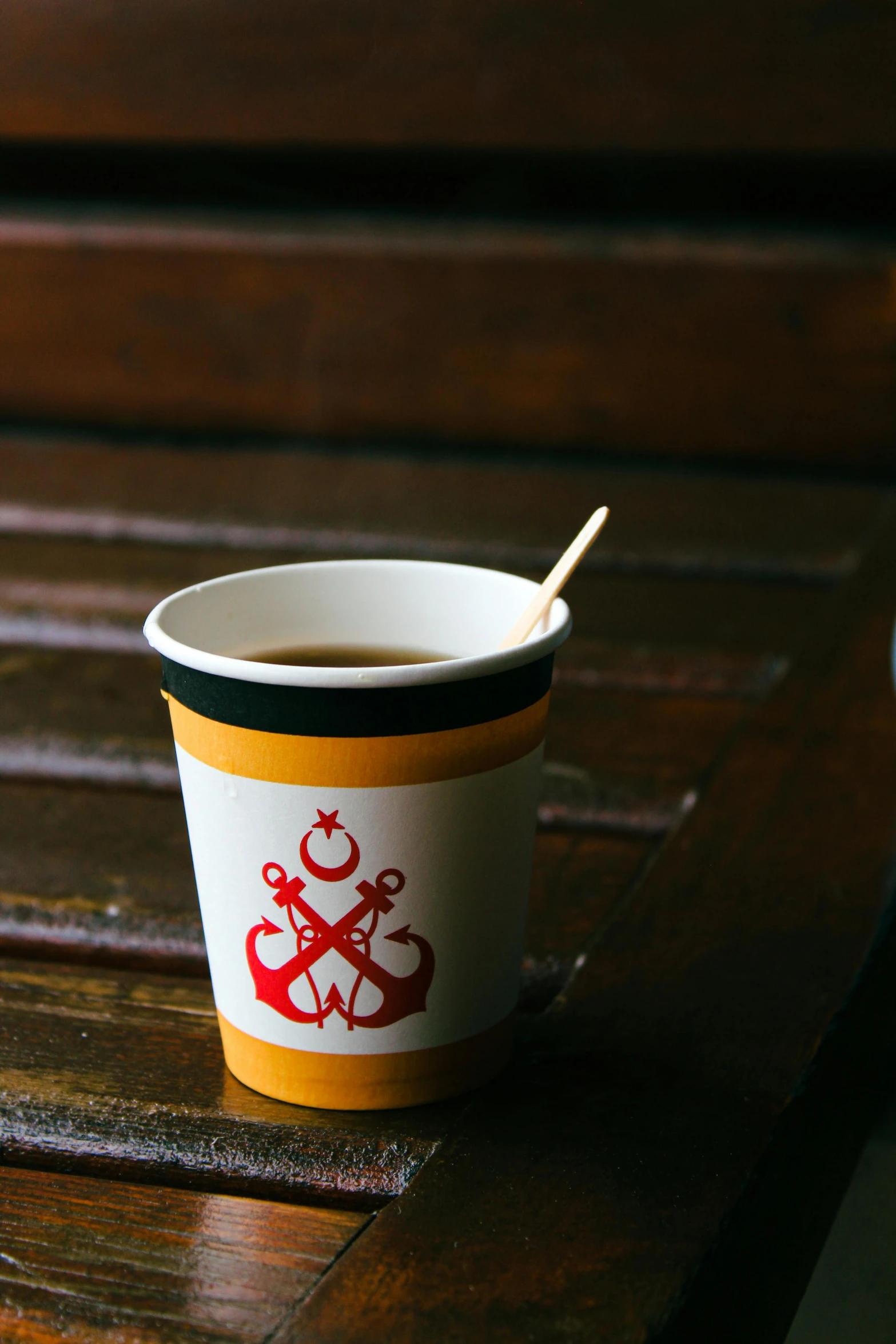 a takeaway coffee cup with a spoon in it