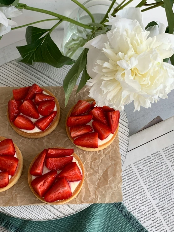 three cookie cups topped with mini desserts and sliced strawberries