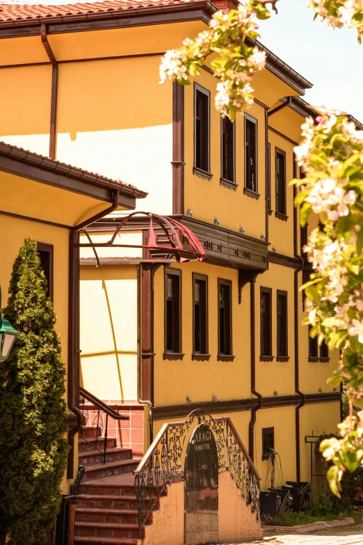 yellow building with stairs and a sign hanging from it