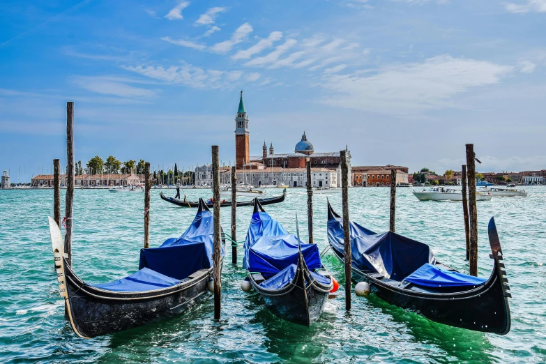 gondolas with blue tarps on the water, venice, italy