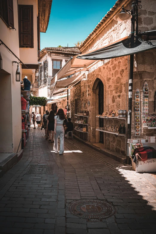 people walking down an old - fashioned street at dusk