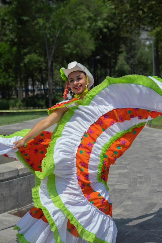 a woman in a colorful dress and hat is dancing on a bench