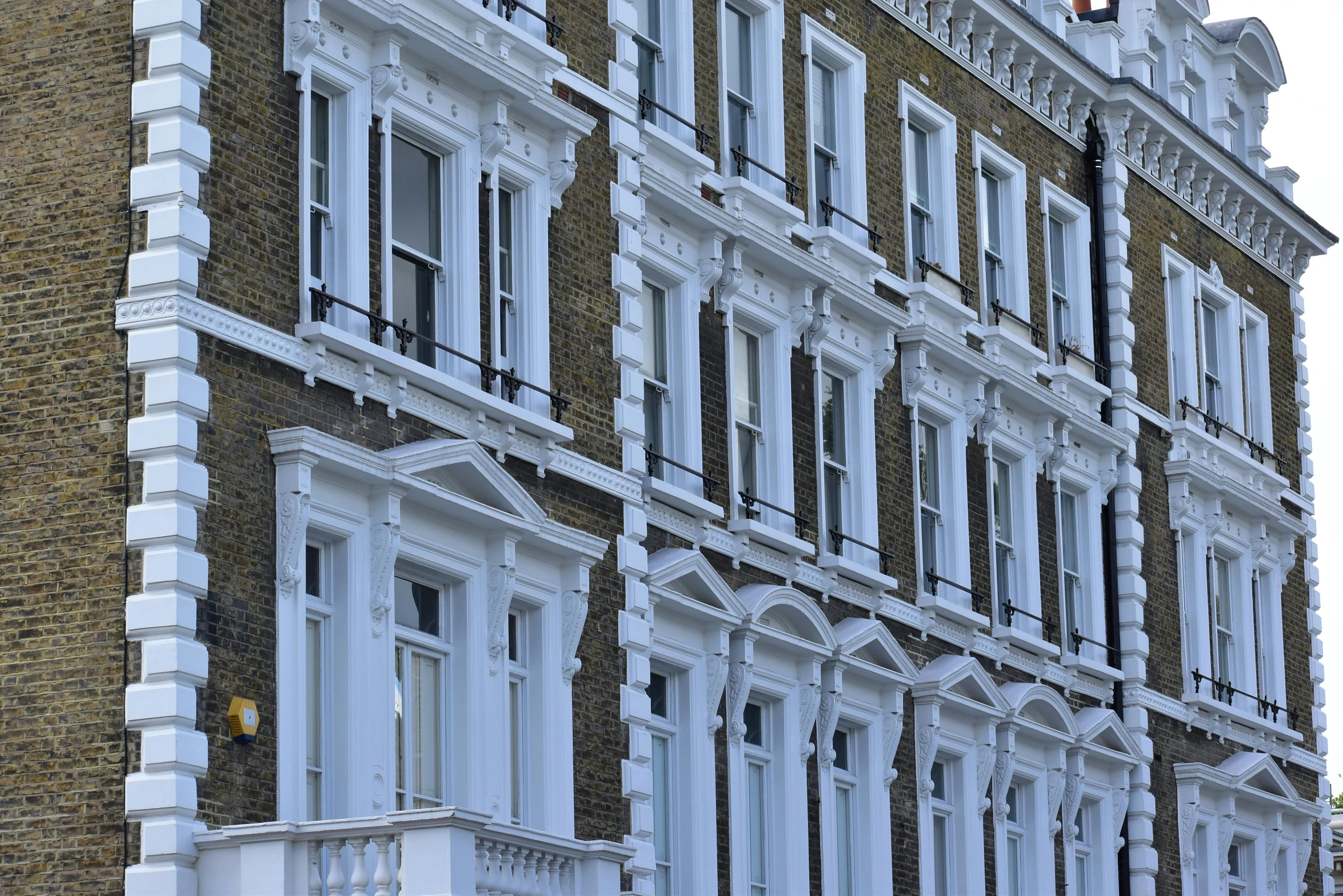 a large brick building with many windows and white balconies