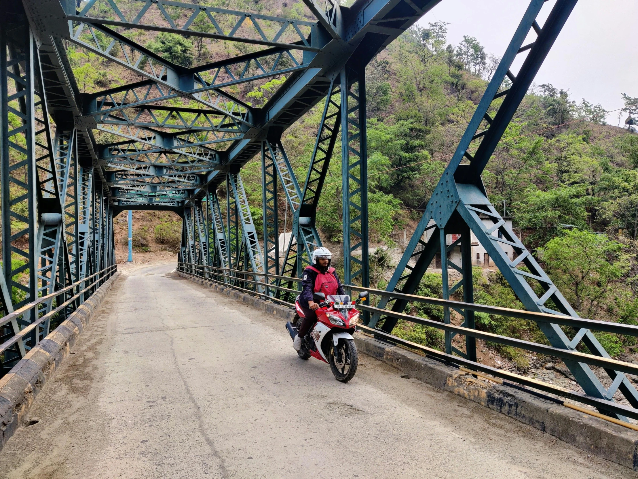 person riding motorcycle down a road under bridge