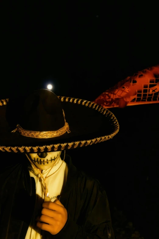 a man with a sombrero hat on standing under a street light