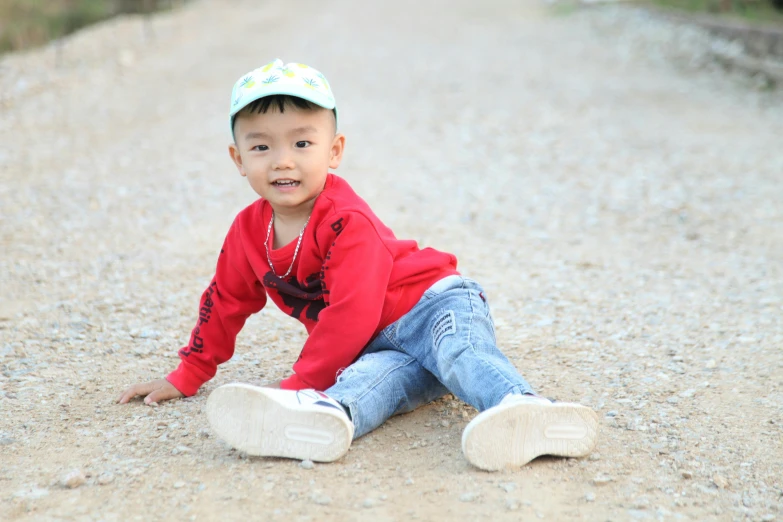 a child playing on the ground in front of a road