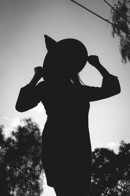 a silhouette of a woman wearing a cat hat