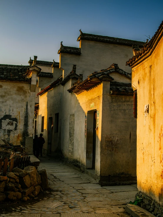 a po of an old alley way with people walking by