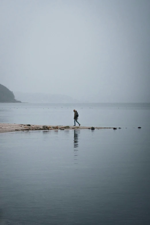 the person is walking across a small island on the water