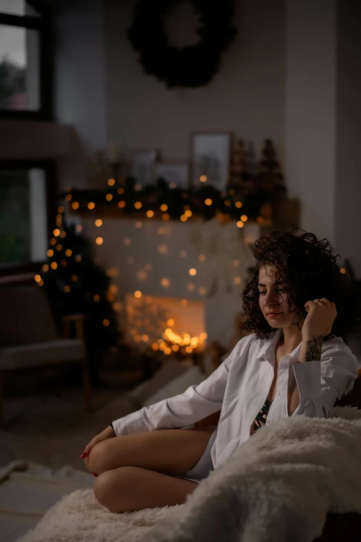 a woman sitting in the middle of a living room talking on a phone